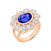 Rose gold ring with a blue gemstone and clear diamonds on a white background